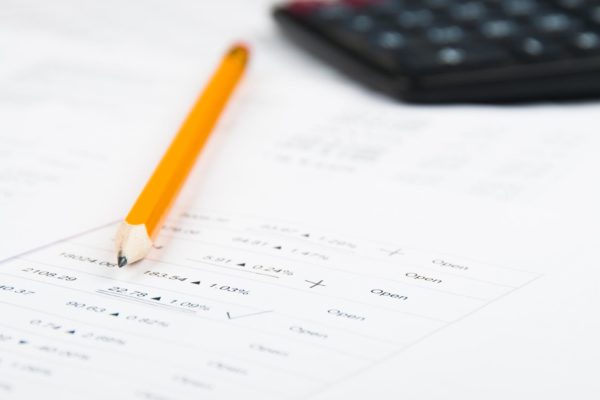 stock analysing on white printed paper yellow pencil and black calculator